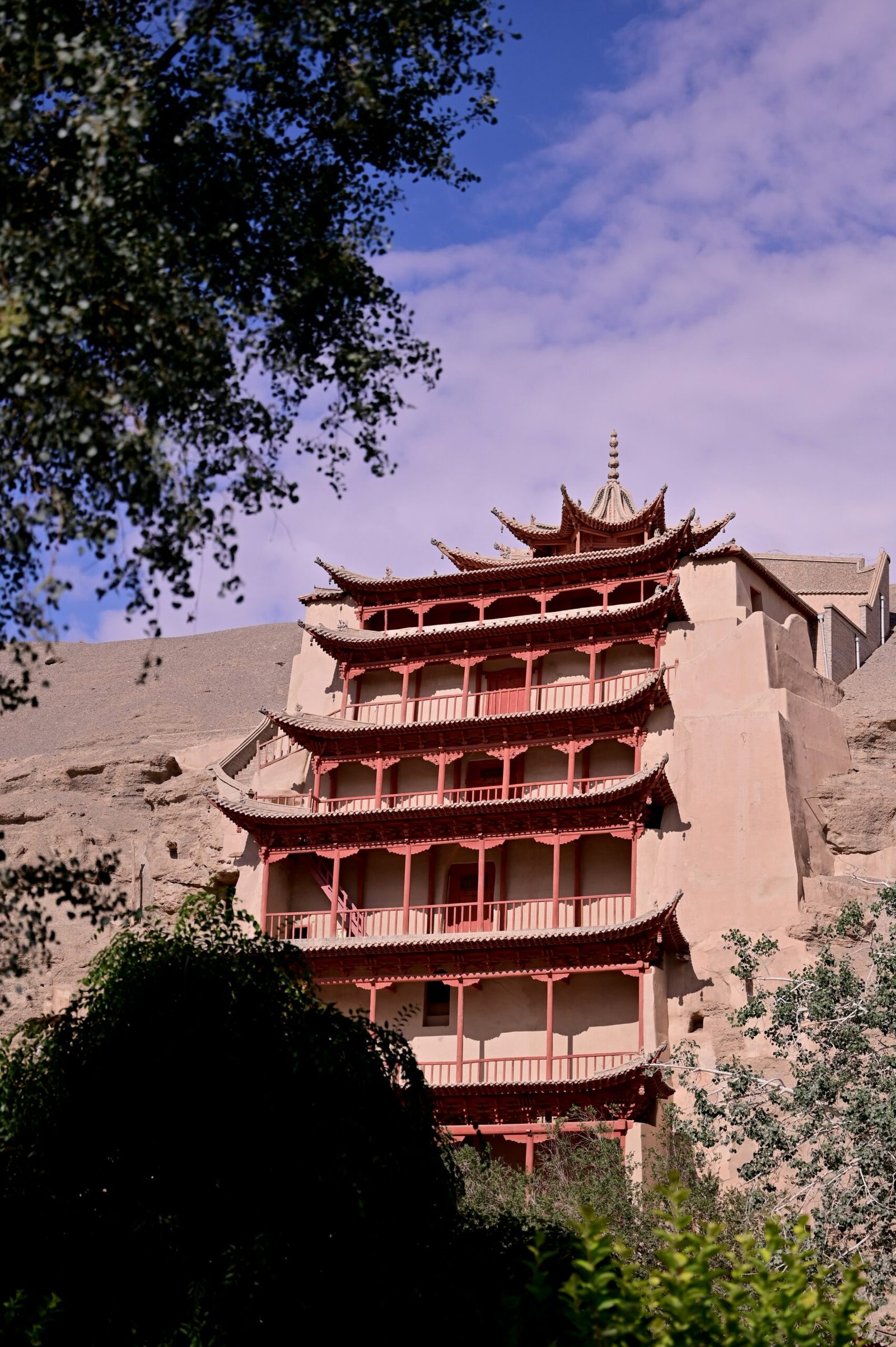 A tall red building sitting on the side of a mountain